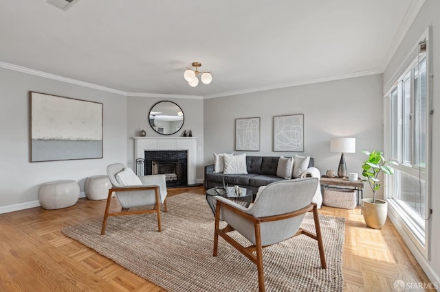 living room featuring a tiled fireplace, crown molding, and light parquet flooring