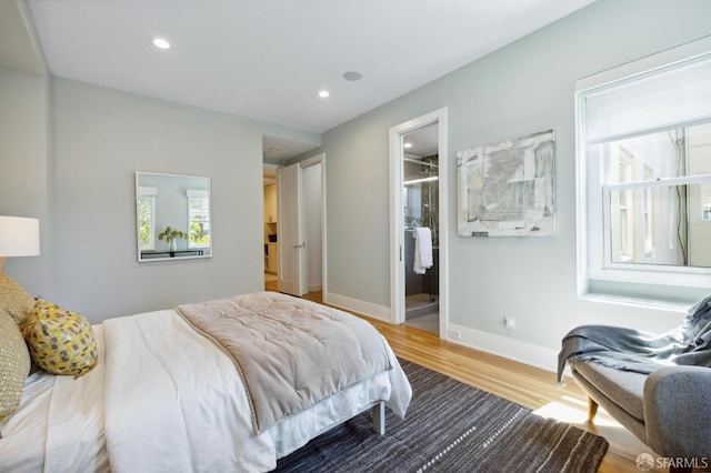 bedroom with wood-type flooring and ensuite bath