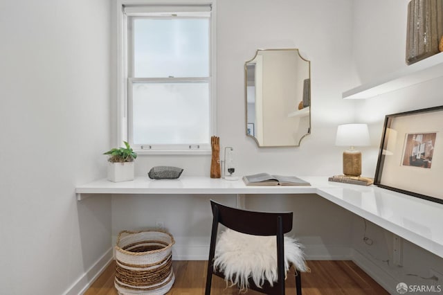 home office featuring built in desk and hardwood / wood-style flooring