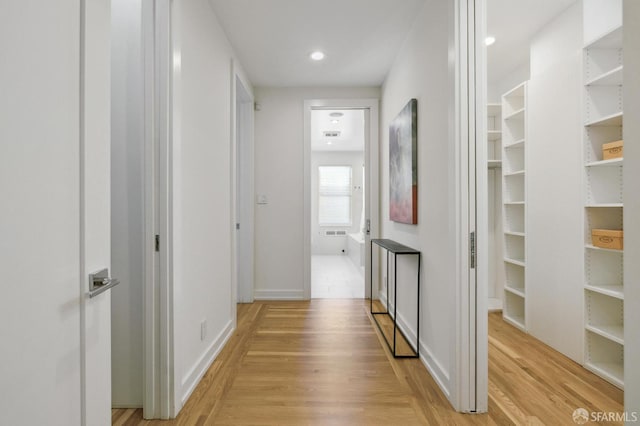 hallway with light hardwood / wood-style floors