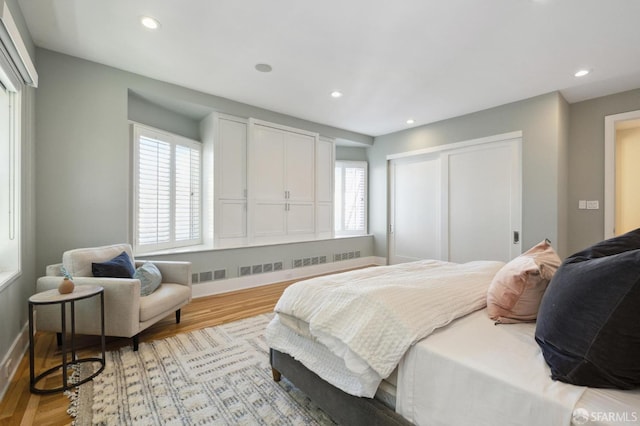 bedroom with light hardwood / wood-style floors and radiator