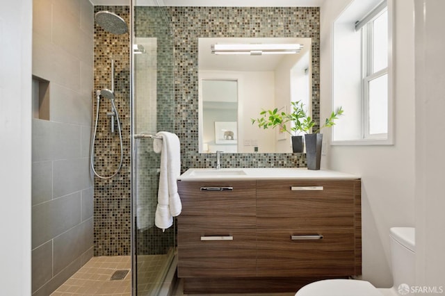 bathroom with decorative backsplash, plenty of natural light, vanity, and toilet