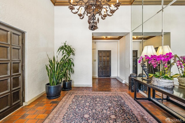 foyer featuring ornamental molding and an inviting chandelier