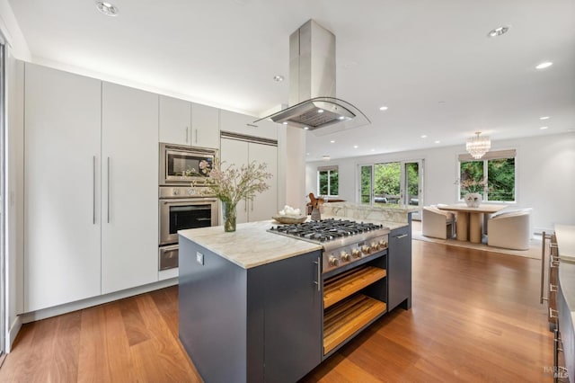 kitchen with stainless steel appliances, island exhaust hood, a kitchen island, dark wood-style floors, and a warming drawer