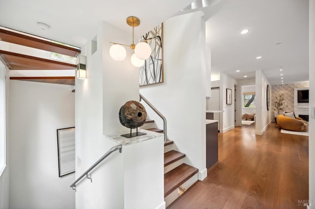 stairway with recessed lighting, baseboards, and wood finished floors