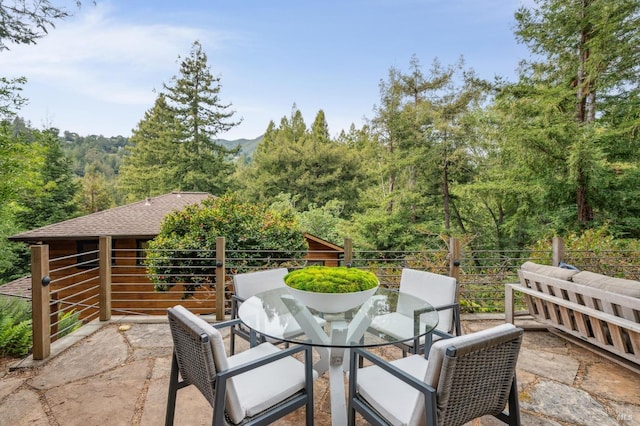 view of patio with a balcony and outdoor dining space