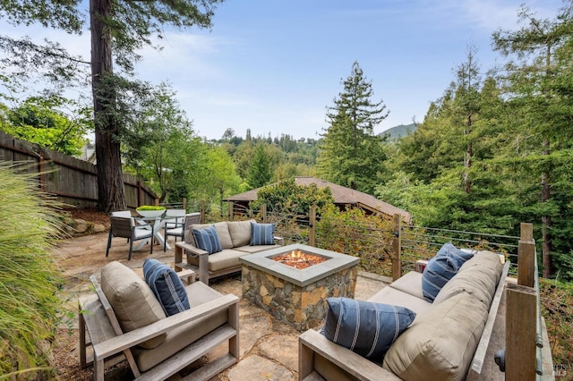 view of patio with fence, outdoor dining space, and an outdoor living space with a fire pit