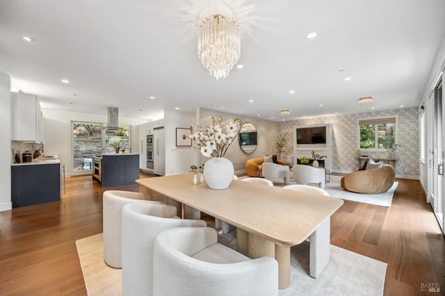 dining area featuring a chandelier, recessed lighting, wood finished floors, and a wealth of natural light
