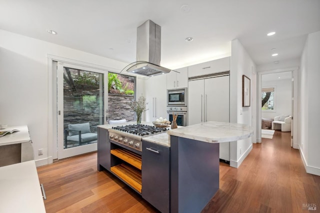kitchen with built in appliances, light wood-type flooring, island range hood, and a center island
