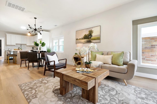 830 47th St, Emeryville, CA 94608 - living area with light wood-style floors, a chandelier, and baseboards