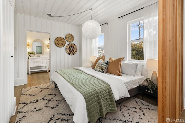 bedroom with ornamental molding and wood finished floors
