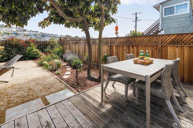deck with a fenced backyard and outdoor dining space