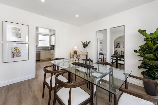 dining space with recessed lighting, baseboards, and light wood-type flooring