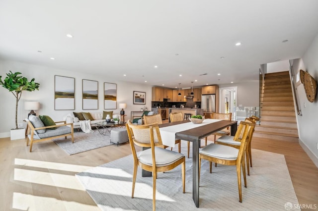 dining space featuring stairway, recessed lighting, light wood-style flooring, and baseboards