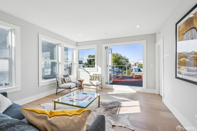 living area featuring recessed lighting, baseboards, and wood finished floors