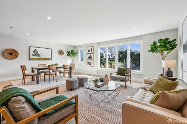 living room featuring recessed lighting, baseboards, and light wood-style flooring