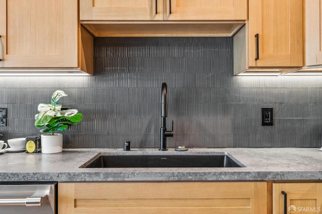 kitchen with dishwasher, light brown cabinetry, backsplash, and a sink