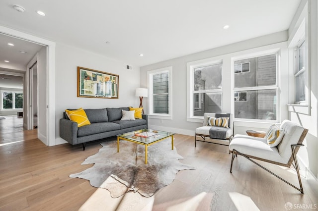 living area with visible vents, recessed lighting, baseboards, and wood-type flooring