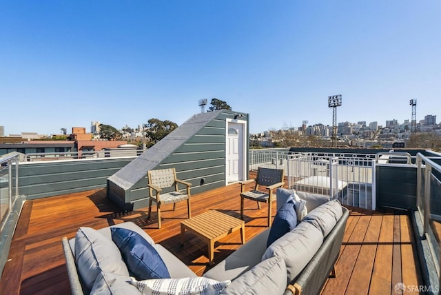 wooden terrace with an outdoor hangout area and a view of city