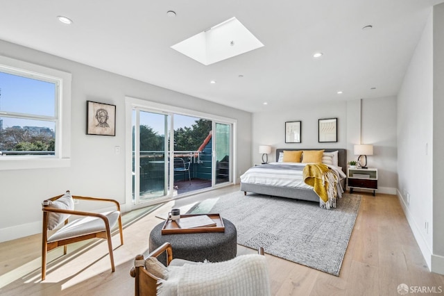 bedroom with access to exterior, baseboards, recessed lighting, light wood-style flooring, and a skylight