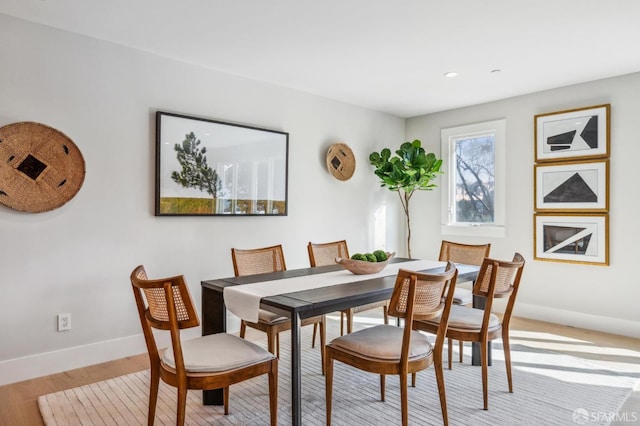 dining area featuring light wood-style flooring and baseboards