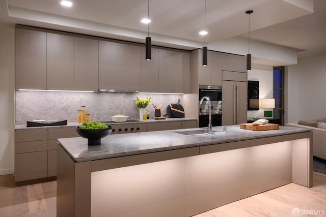kitchen with modern cabinets, gray cabinetry, a sink, and stainless steel appliances