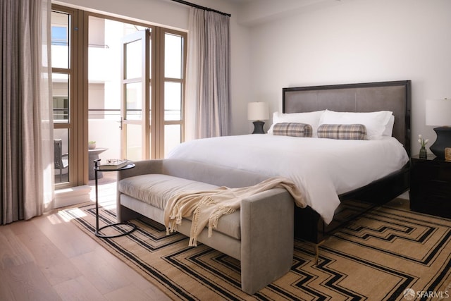 bedroom featuring access to outside and wood finished floors