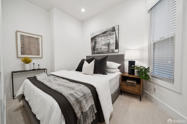 bedroom with recessed lighting, light carpet, baseboards, and multiple windows