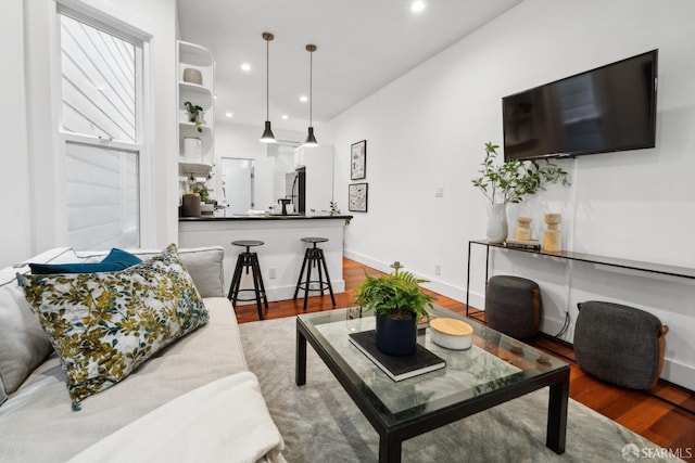 living room with baseboards, wood finished floors, and recessed lighting