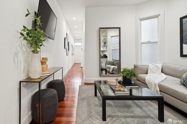 living area featuring baseboards, wood finished floors, and recessed lighting