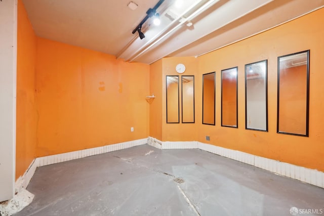 spare room featuring concrete floors and baseboards