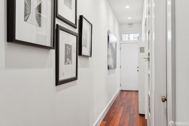 corridor with dark wood-type flooring, recessed lighting, and baseboards