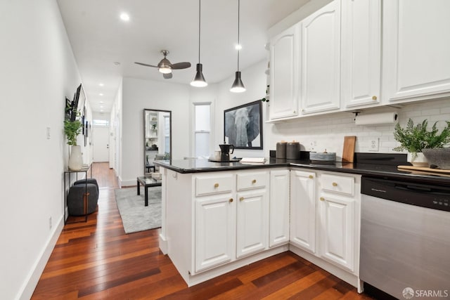 kitchen with a peninsula, dark countertops, backsplash, and stainless steel dishwasher