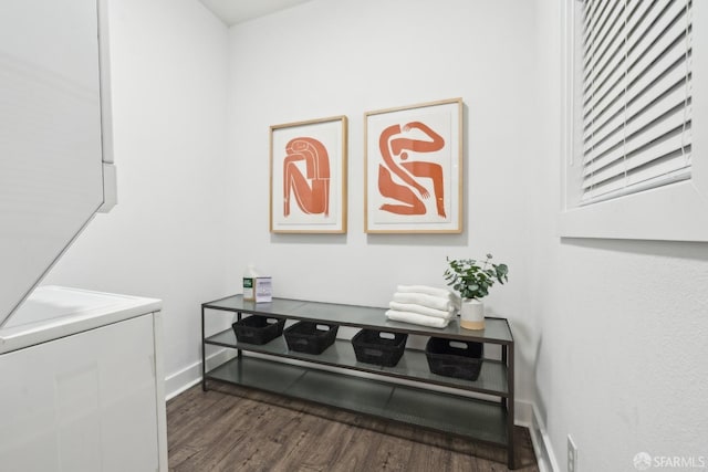 details featuring stacked washer and dryer, wood finished floors, and baseboards