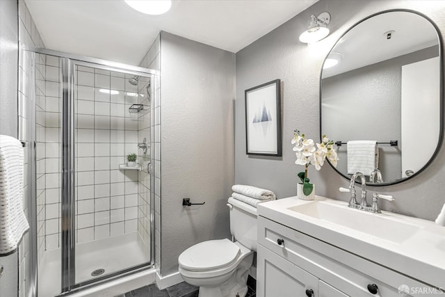 bathroom with vanity, toilet, and a shower with door