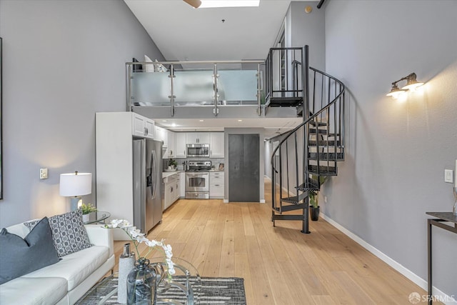 living room featuring light hardwood / wood-style flooring and a high ceiling