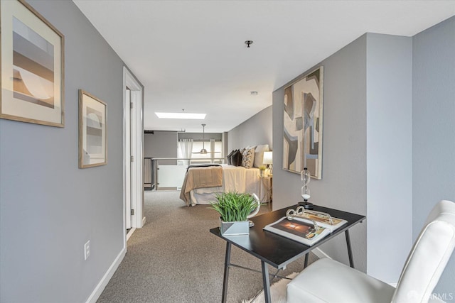 hallway featuring a skylight and carpet