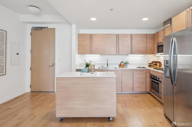 1160 Mission St Unit 2212, San Francisco, CA 94103 - kitchen with stainless steel appliances, light wood-style floors, light countertops, a center island, and recessed lighting