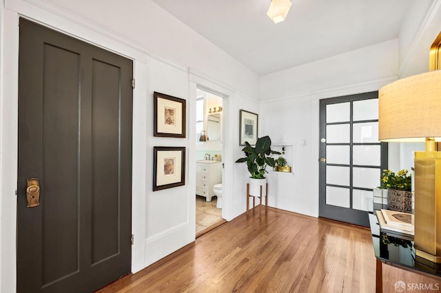 foyer with baseboards and wood finished floors