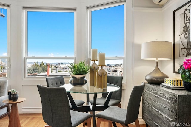 dining room featuring crown molding, wood finished floors, and a healthy amount of sunlight