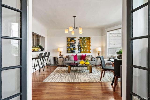 living room with an inviting chandelier and wood finished floors