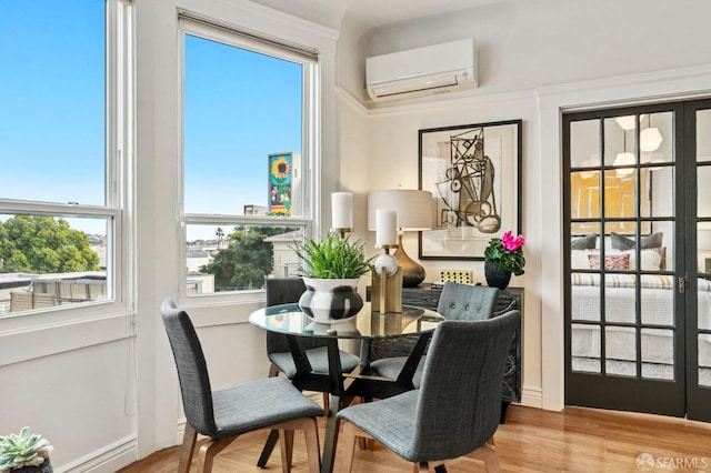 dining space featuring wood finished floors and a wall mounted air conditioner