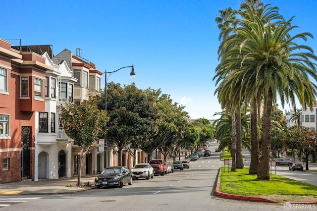 view of street featuring sidewalks, street lighting, a residential view, and curbs