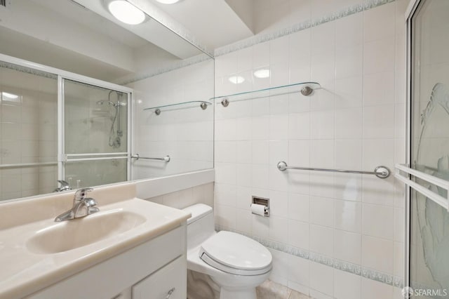 full bath featuring vanity, tile walls, toilet, and a stall shower