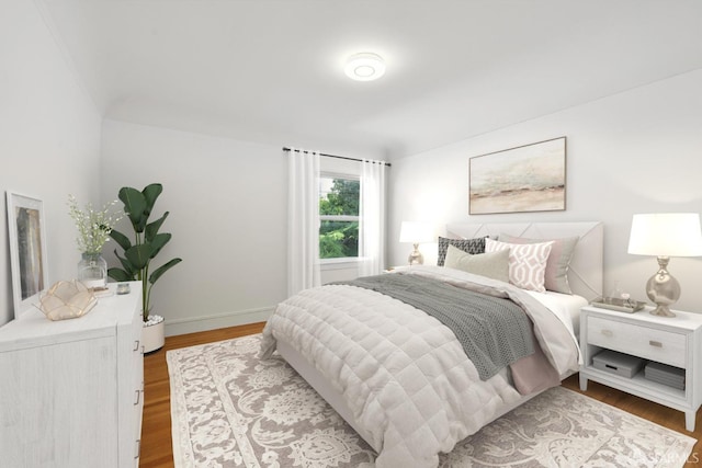 bedroom featuring baseboards and wood finished floors