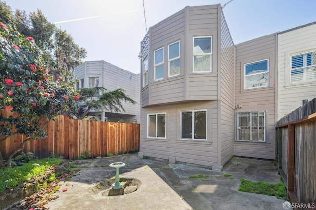 rear view of house with a patio area and fence