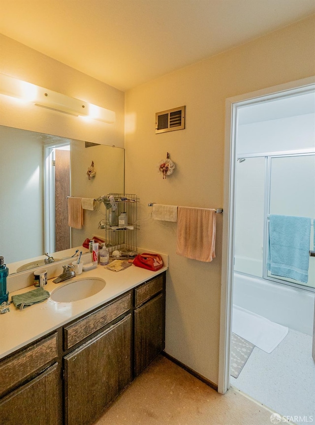 bathroom featuring visible vents, shower / bath combination with glass door, and vanity