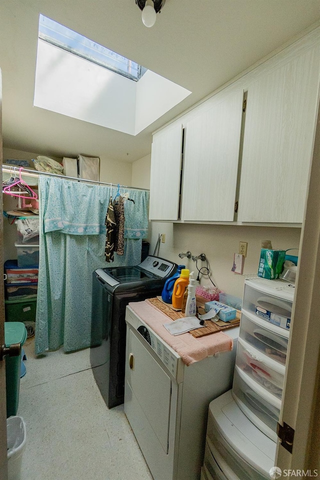 laundry area featuring separate washer and dryer, a skylight, and cabinet space