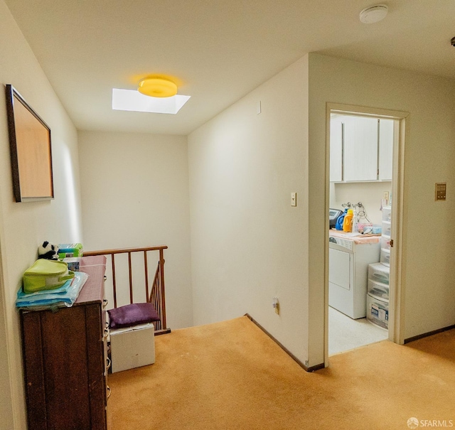 hall featuring carpet, washer / dryer, and a skylight