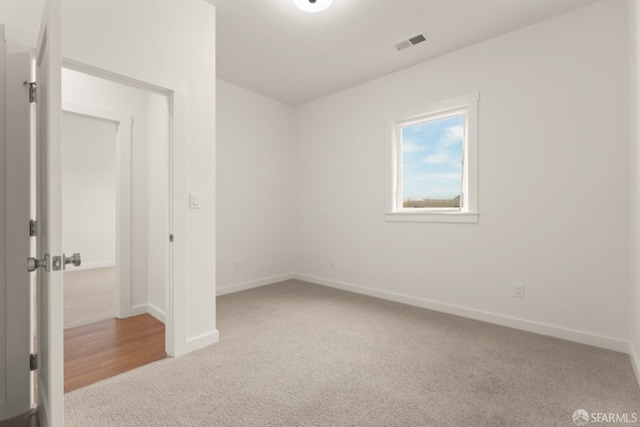 unfurnished bedroom with carpet floors, baseboards, and visible vents